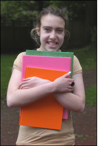 Amy clutching her books and folders for study at Stepping Stones School
