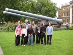 Standing outside and in front of the big naval guns.