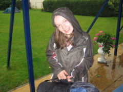 A very wet Amie collects her things from the tent.