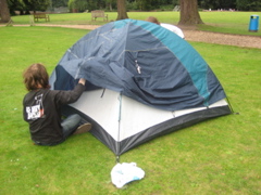 Daniel and Dominic now attach the flysheet to their tent.
